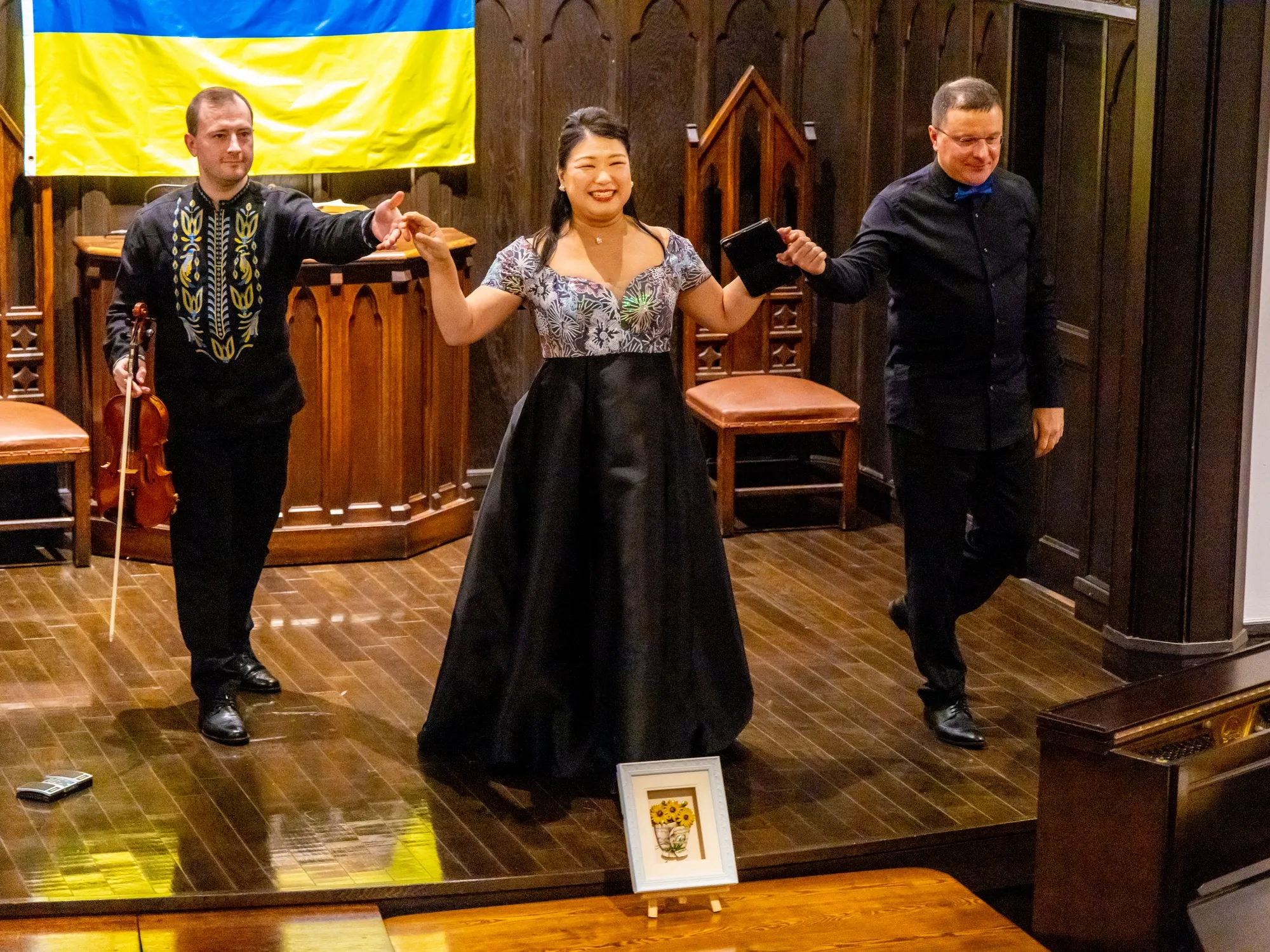 Артисти Нома Аі (контральто), Роман Седволосий (скрипка) та Леонід Шаповалов (піаніно) під час виступу в районі Мінато Мірай