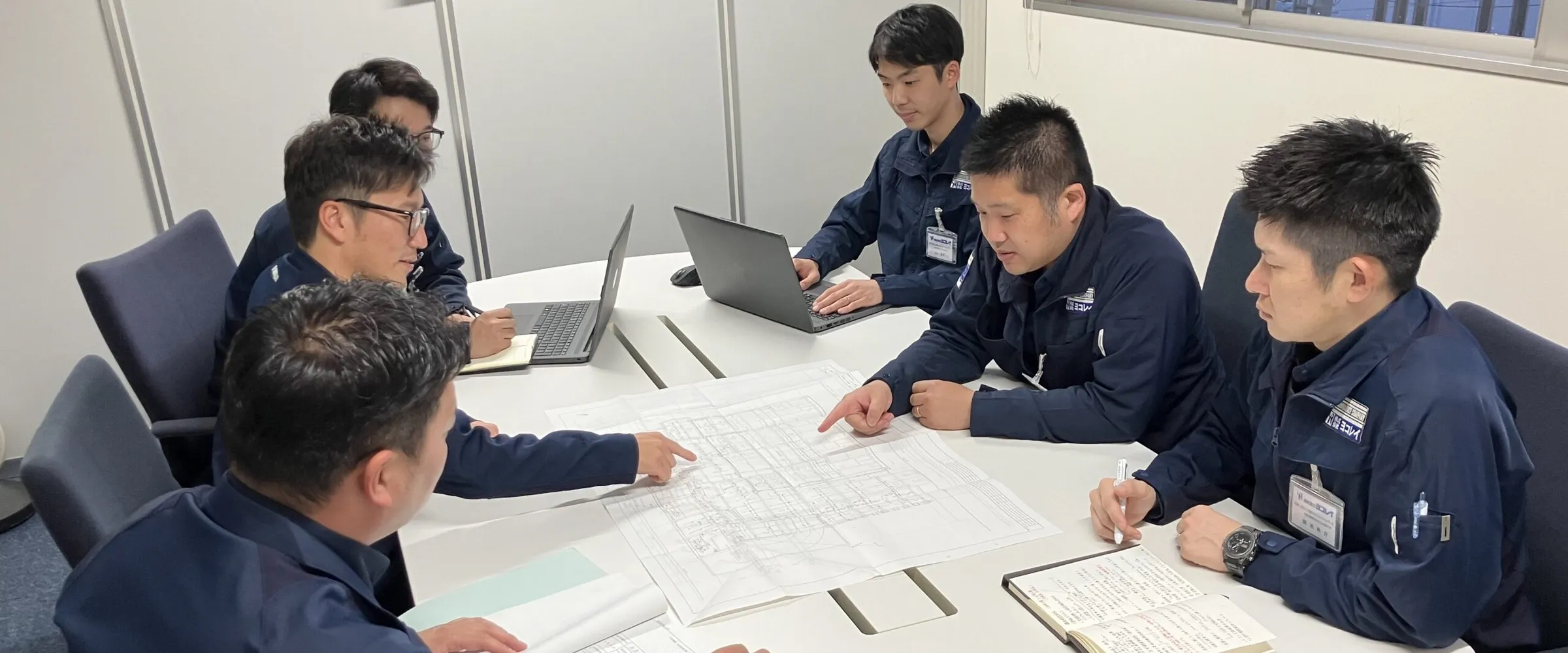 Yokoray engineers discussing facility equipment designs and engineering solutions in the office